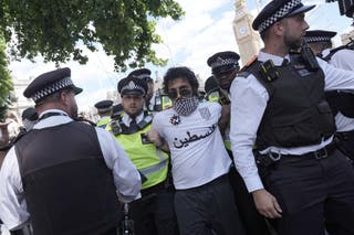 A man is involved by police officers as supporters of Palestinian action in a widespread action in parliament